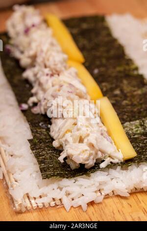 Démonstration du rouleau à sushi sur la façon de placer des ingrédients pour un rouleau à sushi extérieur, avec du riz et des algues Banque D'Images