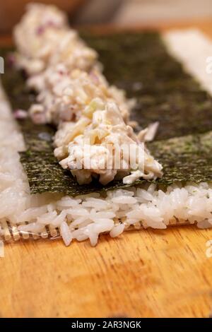 Démonstration du rouleau à sushi sur la façon de placer des ingrédients pour un rouleau à sushi extérieur, avec du riz et des algues Banque D'Images