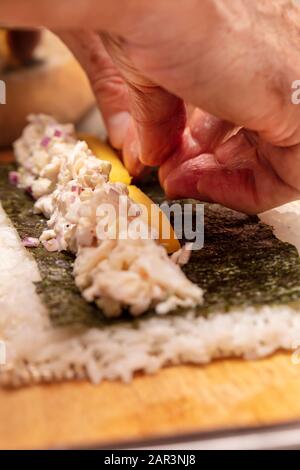 Démonstration du rouleau à sushi sur la façon de placer des ingrédients pour un rouleau à sushi extérieur, avec du riz et des algues Banque D'Images