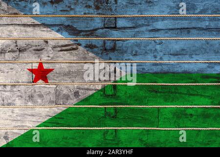 Drapeau national de Djibouti sur un fond de mur en bois. Le concept de fierté nationale et un symbole du pays. Drapeaux peints sur une clôture en bois wi Banque D'Images