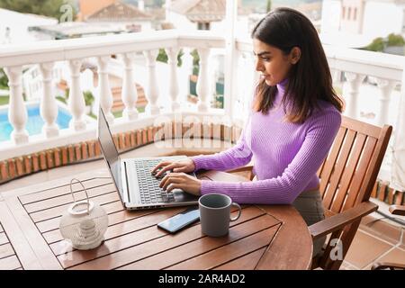 Persian femme sur son balcon à l'aide d'un ordinateur portable Banque D'Images