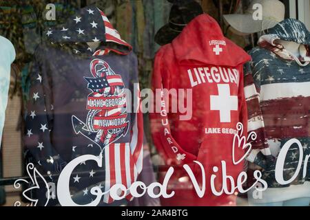 5 août 2019 - Lac George, NY, États-Unis : drapeau américain et Hoodies de Sauvguard exposés dans une vitrine de magasin à Lake George Town, boutique de souvenirs, Canada St Banque D'Images