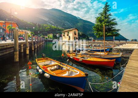 Spectaculaire bord de mer et port avec des bateaux en bois colorés ancrés sur le lac de Garde, Torbole Resort, Italie, Europe Banque D'Images