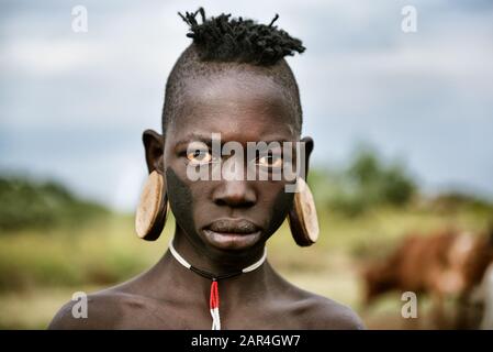 Omo VALLEY, ETHIOPIE - 11 AOÛT 2018 : Boy de la tribu africaine Mursi pose pour un portrait Banque D'Images