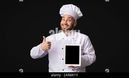 Homme Cuisinier Montrant Tablette Écran Gestuelle Thumbs-Up, Studio, Maquette Banque D'Images