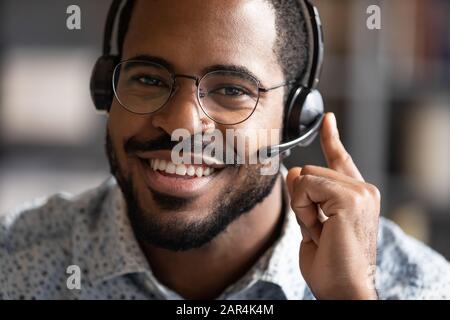 Un opérateur de télémarketing africain heureux porte un portrait de casque sans fil Banque D'Images