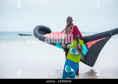Maasai sur la plage de Kitesurfing à Diani Beach, Kenya, tenant un kite, équipement de kite pour kiteboarding, kite-surf école apprendre kite-boarding Banque D'Images