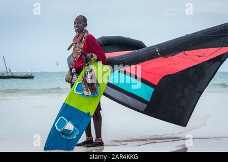 Maasai sur la plage de Kitesurfing à Diani Beach, Kenya, tenant un kite, équipement de kite pour kiteboarding, kite-surf école apprendre kite-boarding Banque D'Images
