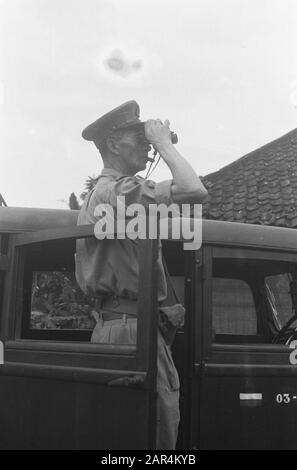 Garoet. Purification actions environnement Tjibatoe et Wanaradja officier avec cigare regarde à travers des jumelles du marchepied de son personnel voiture Date: 15 octobre 1947 lieu: Indonésie, Java, Pays-Bas East Indies Banque D'Images