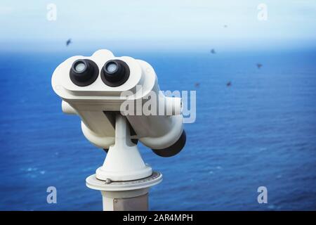 Télescope binoculaire touristique regardant le gros plan de l'océan bleu. Banque D'Images