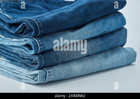 Des jeans sont posés sur la table. Tissus Denim Vêtements Fond Pile Concept. Sur un fond blanc isolé Banque D'Images