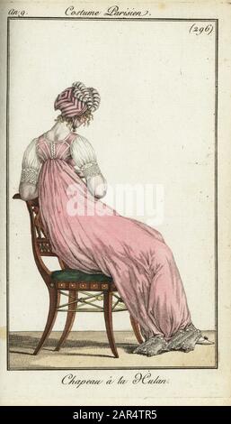 Vue arrière d'une femme à la mode dans une casquette Uhlan, 1801. Le chapeau avait une couronne en forme de losange et s'est retourné à l'avant comme un casque d'Uhlan lancer et a été porté par les elegantes de Longchamps. Elle porte une robe à manches courtes avec taille haute. Chapeau A la Hulan. Gravure en copperplate de couleur à la main du Journal des modes et Dames de Pierre de la Mesangere, Paris, 1801. Les illustrations du volume 4 étaient Carle Vernet, Bosio, Dutailly et Philibert Louis Debucourt. Banque D'Images