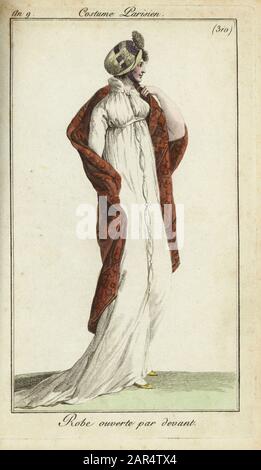 Femme à la mode avec chapeau de paille, robe et châle, 1801. Son chapeau de paille est attaché sous le menton, la robe haute taille est ouverte sur le devant et attachée avec des boutons. Peignoir par devant. Gravure en copperplate de couleur à la main du Journal des modes et Dames de Pierre de la Mesangere, Paris, 1801. Les illustrations du volume 4 étaient Carle Vernet, Bosio, Dutailly et Philibert Louis Debucourt. Banque D'Images