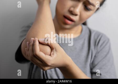 Femmes avec douleur dans le coude. Douleur aiguë dans un coude. La jeune femme tient au coude. Banque D'Images