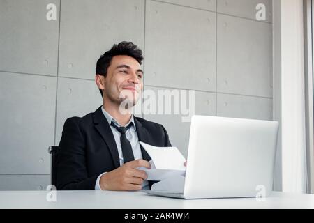 Homme d'affaires a ouvert l'enveloppe avec des symptômes d'ecstasy. L'employé masculin était content après avoir lu les messages insérés document qu'il détient. Banque D'Images