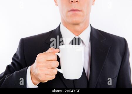 Gros plan photo d'un homme d'affaires sérieux tenant une tasse de café Banque D'Images