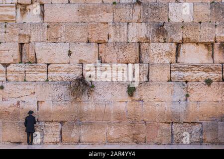 Un homme juif orthodoxe se tenant au mur occidental de Jérusalem, en Israël. Banque D'Images