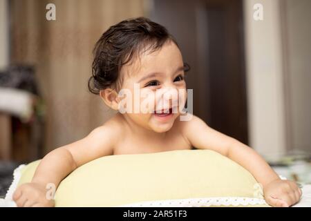 Portrait de Bébé indien De Six mois Avec sourire et jouer avec la famille dans la chambre avec éclairage naturel Banque D'Images