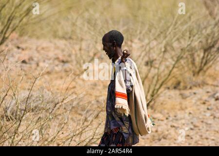 Berger éthiopien marchant dans le paysage d'Afar, Ethiopie. Les ancêtres de l'Afar ont installé des terres agricoles dans les hautes terres éthiopiennes un peu avant AD Banque D'Images