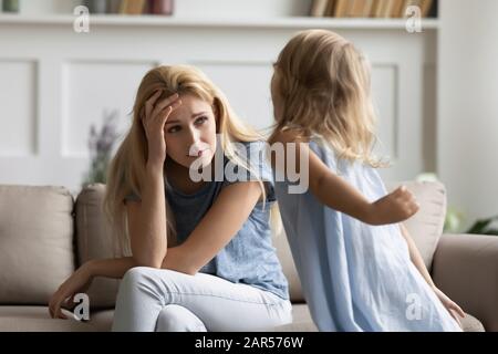 Jeune femme stressée irritée par un enfant hyperactif très fort. Banque D'Images