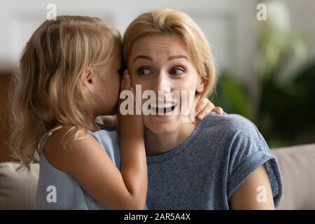 Petite fille d'âge préscolaire partage secret avec momie. Banque D'Images