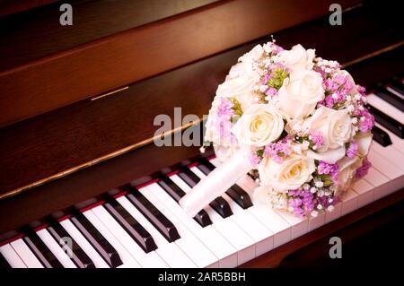 le bouquet de la mariée se trouve sur le clavier du piano à proximité Banque D'Images