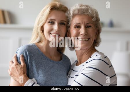 Heureuse femme d'âge moyen câlin belle fille grognup. Banque D'Images