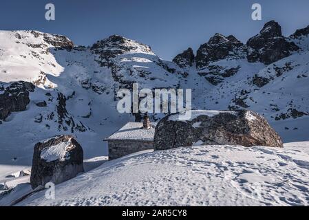 Refuge de lacs effrayants en hiver devant un lac gelé dans le parc national de la montagne de Rila, en Bulgarie Banque D'Images