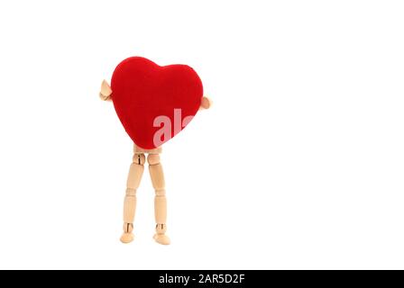 Une poupée en bois tenant un coeur sur un fond blanc Banque D'Images