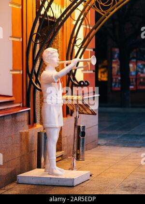 Moscou, Russie - 17 janvier 2020: Entrée au café de rue dans le centre-ville en soirée. Porche avec éclairage lumineux et sculpture de l'ère soviétique de Banque D'Images