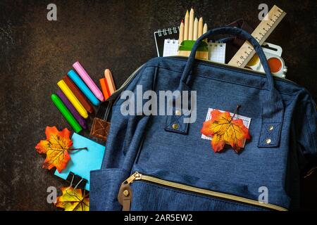 Retour au concept scolaire. Fournitures scolaires avec sac à dos bleu sur la table. Vue sur le dessus plat. Banque D'Images