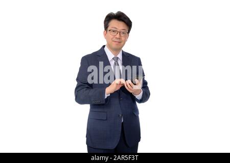 Homme d'affaires asiatique d'âge moyen utilisant un smartphone mobile sur un fond blanc. Banque D'Images