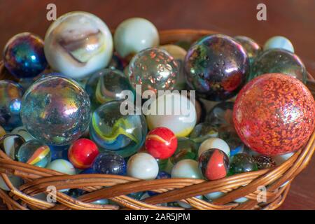 Divers marbres en verre dans un panier décoratif en osier Banque D'Images