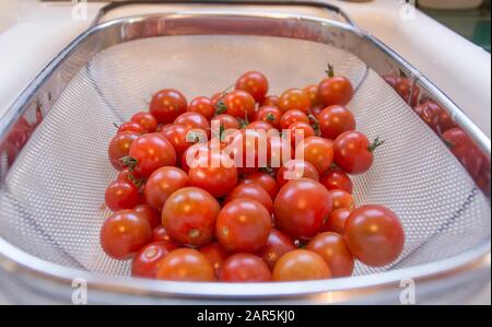 Belle dose de tomates cerises rouges dans une passoire en métal Banque D'Images