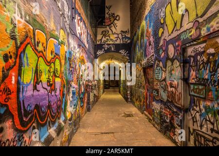 Croque dans une rue étroite avec des graffitis colorés partout les murs Banque D'Images