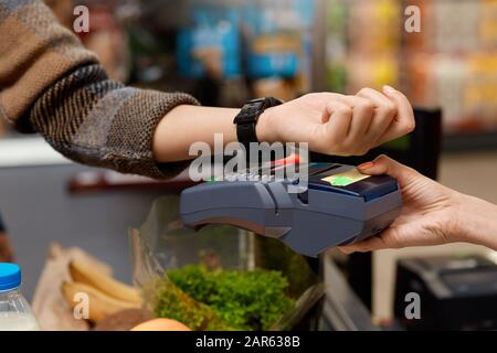 Achats Quotidiens. Femme debout au guichet du caissier du supermarché payant pour des achats sans contact avec la plus grande proximité Banque D'Images