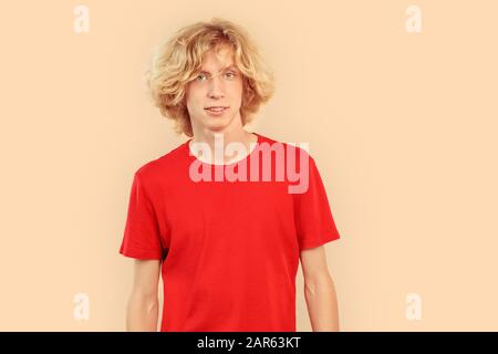 Jeune homme regardant l'appareil photo et souriant gentil Banque D'Images