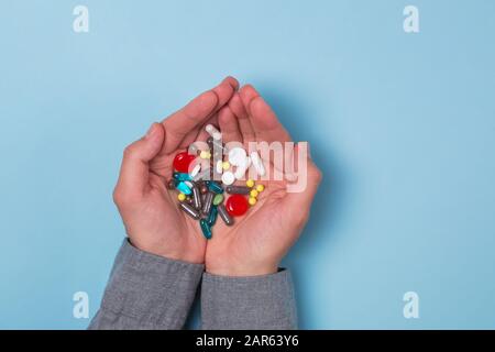 Les mains de l'homme tenant beaucoup de comprimés et de pilules différents dans ses mains Banque D'Images