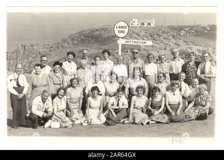 La photo commerciale de groupe de trippers de jour des années 1950 en vacances de Nottingham pose pour une photo à côté du célèbre signpost à Land's End, Cornwall, Royaume-Uni, daté d'août 1955 Banque D'Images