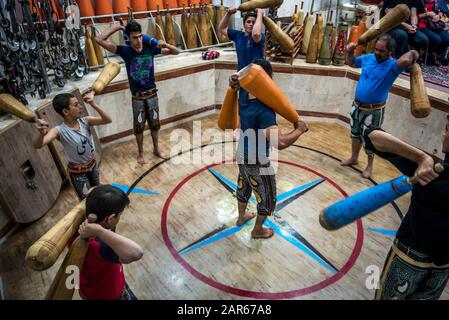 Les hommes et les garçons iraniens avec formation clubs en bois en Zoorkhaneh (Maison de la Force), gymnase traditionnel de Yazd, ville de la province de Yazd Iran Banque D'Images