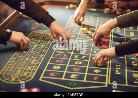 Une main avec plaquettes fait un pari sur la roulette dans un casino. Banque D'Images