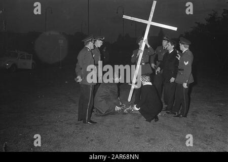 Croix pour les victimes Vietnam à la place du Musée à Amsterdam. À genoux, M. Klein et Mme J. de Vries-Mull y jettent des fleurs, tandis que Agent élimine la croix. Date: 21 octobre 1967 lieu: Amsterdam, Noord-Holland mots clés: Fleurs, croix, police, protestations Nom personnel: Vries-Mull J. de Banque D'Images