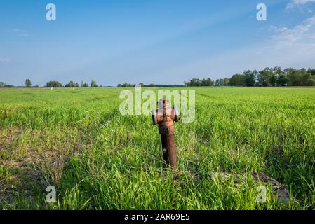 Old rusty sur un poteau incendie champ de seigle dans petit village de la région de Mazovie, Pologne Banque D'Images