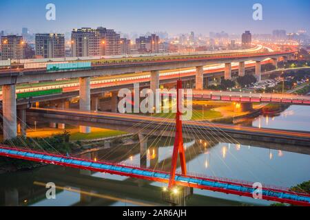 Taipei, les ponts et les routes de Taïwan au-dessus de la rivière Keelung au crépuscule. Banque D'Images