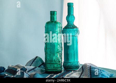 Bouteille de vin toujours vie avec deux bouteilles en verre bleu fait à la main en verre recyclé espagnol devant la fenêtre - image horizontale avec s Banque D'Images