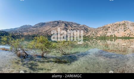 Panorama du lac naturel d'eau douce Kournas près de Georgioupolis, les montagnes blanches se reflètent dans l'eau avec des arbustes, Crète, Grèce Banque D'Images