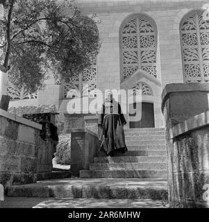 Israël 1948-1949: Ain Karem Monk, probablement un franciscain, dans l'habitude sur les marches devant l'Église de la Visitation Date: 1948 lieu: Ain Karem, Israël, Jérusalem mots clés: Perlé, bâtiments d'église, ordres monastiques, moines, fenêtres, escaliers Banque D'Images