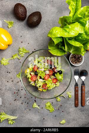 Salade aux légumes frais olives tomates oignon rouge fromage grec feta et huile d'olive isolée sur fond gris. Vue de dessus. Banque D'Images