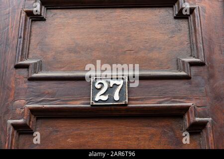 Grunge métal maison plaque avec 27 sur le mur extérieur, le numéro 27 sur une porte en bois. Banque D'Images