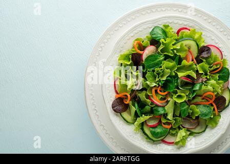 Salade verte saine avec légumes frais sur fond de table bleu Banque D'Images